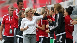 Bundestrainerin Silvia Neid (in weiß) klatscht die Spielerinnen an. © imago/ MIS 