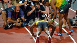 Yohan Blake (r.) schaut zu wie Usain Bolt Liegestütze macht. © imago/Xinhua Foto: Xinhua