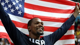 Der amerikanische Basketballer Kevin Durant feiert mit der Flagge. © Imago/Fotoarena