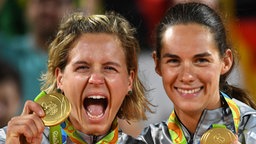 Die deutschen Beachvolleyballspielerinnen Laura Ludwig (l.) und Kira Walkenhorst mit ihren olympischen Goldmedaillen. © dpa Foto: Sebastian Kahnert