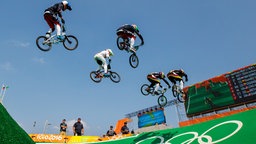 Mehrere BMX-Fahrer fliegen durch die Luft. © Imago/Xinhua