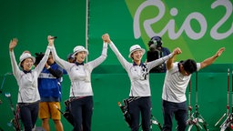 Die südkoreanischen Bogenschützinnen feiern ihren Sieg mit ihrem Trainer. © picture alliance / dpa Foto: Diego Azubel