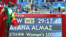 Die Äthiopierin Almaz Ayana posiert vor der Anzeige ihres Weltrekordes. © Imago/Xinhua