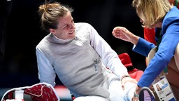 Die deutsche Fechterin Carolin Golubytskyi wird während ihres Kampfs gegen die Polin Hanna Lyczbinska verarztet. © dpa - Bildfunk Foto: Felix Kästle