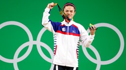 Die taiwanesische Gewichtheberin Shu-Ching Hsu präsentiert ihre Goldmedaille. © DPA Bildfunk Foto: Nic Bothma