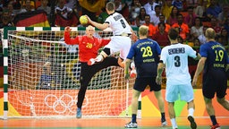Der deutsche Handball-Spieler Tobias Reichmann (M., Nr. 9) trifft gegen Schweden. © dpa - Bildfunk Foto: Marijan Mura