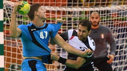 Der deutsche Handballer Christian Dissinger (l.) beim Zweikampf gegen Ägyptens Mohammad Sanad © dpa - Bildfunk Foto: Marijan Murat