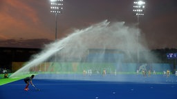 Die Wassersprinkleranlage geht während eines Hockey-Spiels an. © dpa - Bildfunk Foto: Friso Gentsch