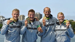 Das Team des deutschen Kanu-Vierers jubelt über Gold. © dpa Foto: Soeren Stache