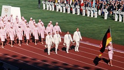 Ingrid Engel-Krämer 1964 beim Einmarsch der Nationen in das Olympiastadion von Tokio während der Eröffnung Olympischen Spiele die deutsche Fahne. © picture-alliance / dpa