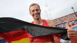 Hochspringer Eike Onnen mit einer Deutschland-Fahne. © DPA Picture Alliance Foto: Michael Kappeler