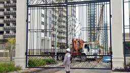 Ein Bauarbeiter steht vor dem Tor zum Olympischen Dorf Ilha Pura in Rio de Janeiro. Die Anlage besteht aus 31 Hochhäusern mit 17 Stockwerken.  © picture alliance / dpa Foto: Georg Ismar