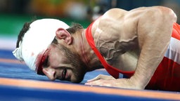 Der russische Ringer Aniuar Geduev liegt verletzt am Boden. © Imago/ITAR-TASS