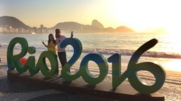 Olympiatouristen posieren zum Sonnenaufgang vor dem "Rio 2016"-Schriftzug. © picture alliance / SvenSimon Foto: Frank Hoermann
