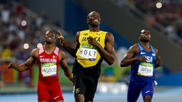 Usain Bolt (M.) lächelt. © Imago/Fotoarena 
