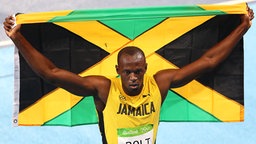 Usain Bolt jubelt mit der Jamaika-Flagge. © DPA Picture Alliance Foto: Mike Egerton