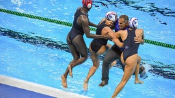 Die amerikanischen Wasserballerinnen werfen ihren Trainer ins Wasser. © DPA Picture Alliance Foto: Wang Haofei