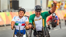 Der italienische Radfahrer Alessandro Zanardi (l.) kommt hinter dem Südafrikaner Ernst van Dyk ins Ziel. © dpa - Bildfunk Foto: Jens Büttner