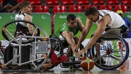 Der deutsche Rollstuhlbasketballer Sebastian Magenheim (r.) kämpft mit Algeriens Mostefa Abassi (M.) um den Ball. © imago/Agencia EFE 