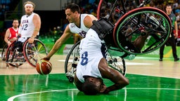 Der US-amerikanische Rollstuhl-Basketballer Brian Bell (v.) fällt mit seinem Rollstuhl. © Olympic Information Services OIS Foto: Thomas Lovelock