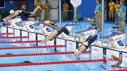 Die Schwimmerinnen starten das Rennen über 100 Meter Brustschwimmen. © dpa - Bildfunk