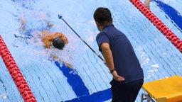 Ein "Tapper" warnt einen blinden Schwimmer vor dem nahenden Beckenrand © imago/AFLOSPORT 