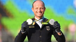 Der deutsche Reiter Michael Jung zeigt seine Medaillen. © Witters Foto: Valeria Witters