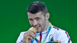 Der serbische Ringer Davor Stefanek posiert während der Siegerehrung der Olympischen Spiele. © dpa