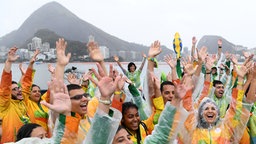 Freiwillige Helfer jubeln im Lagoa Stadion, der Austragungsstätte der Ruderwettkämpfe bei den Olympischen Spielen in Rio de Janeiro. © dpa - Bildfunk Foto: Soeren Stache