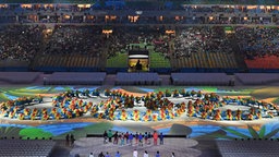Tänzer bilden die Olympischen Ringe. © dpa - Bildfunk Foto: Sebastian Kahnert
