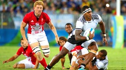 Der Rugbyspieler Semi Kunatani (r.) aus Fidschi beim Zweikampf gegen den Briten James Rodwell © dpa - Bildfunk Foto: Friso Gentsch