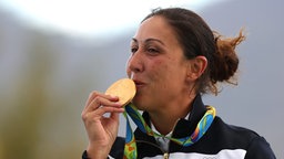 Die italienische Sportpistolen-Schützin Diana Bacosi mit ihrer olympischen Goldmedaille © dpa - Bildfunk Foto: Armando Babani