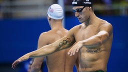 Italiens Schwimmer Federico Turrini zeigt seine Tattoos vor dem Rennen. © Imago/Bildbyran