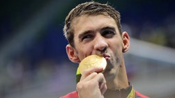 US-Schwimmer Michael Phelps küsst seine Goldmedaille. © DPA Bildfunk Foto: Michael Kappeler