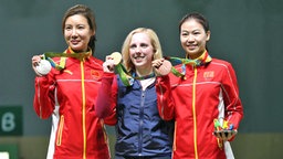 Virginia Thrasher (M.) aus den USA gewinnt die erste Goldmedaille im Luftgewehr-Schießen in Rio 2016. Neben ihr sind die Chinesinnen Du Li (l. Silber) und Yi Siling (Bronze). © Witters Foto: Geoff Burke