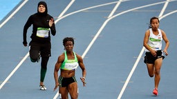 Die Sprinterinnen Kariman Abuljadayel aus Saudi Arabien, Prenam Pesse aus Togo und Karitaake Tewaaki aus Kiribati bei den Olympischen Spielen in Rio. © dpa bildfunk Foto: Antonio Lacerda