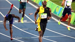 Die jamaikanische Sprinter Usain Bolt (M.) läuft ins Ziel. © dpa - Bildfunk Foto: Antonio Lacerda