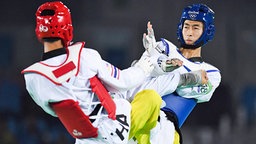 Die Taekwondo-Kämpfer Zhao Shuai (r.) aus China und Tawin Hanprab aus Thailand bei einem Kampf während der Olympischen Spiele in Rio. © imago 