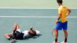 Der deutsche Tennisspieler Dustin Brown (l.) liegt neben dem Brasilianer Thomaz Bellucci verletzt am Boden. © dpa - Bildfunk Foto: Michael Reynolds