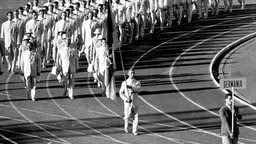 Fritz Thiedemann trägt bei der Eröffnungsfeier der Olympischen Spiele in Rom 1960 die Fahne der deutschen Mannschaft. © imago/Horstmüller