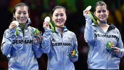 Die deutschen Tischtennisspielerinnen Ying Han, Xiaona Shan und Petrissa Solja (v.l.n.r.) bei der Siegerehrung © dpa - Bildfunk Foto: Lukas Schulze