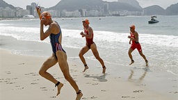 Die Triathletinnen Gwen Jorgensen (USA), Nicola Spirig (Schweiz) und Barbara Riveros (Chile) (v.l.n.r.) kommen aus dem Wasser. © dpa Foto: Peter Klaunzer