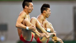 Die chinesischen Wasserspringer Aisen Chen und Yue Lin (v.l.) springen ins Wasser.  © dpa Bildfunk Foto: Felix Kästle