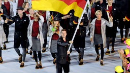 Timo Boll trägt die deutsche Fahne bei der Olympia-Eröffnungsfeier 2016. © picture alliance / dpa