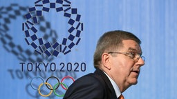 IOC-Präsident Thomas Bach vor dem Logo der Olympischen Spiele in Tokio © imago images /Sven Simon 