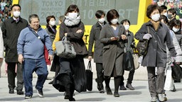 In Tokios Einkaufsviertel Ginza tragen Passanten einen Mundschutz. © imago images / Kyodo News 