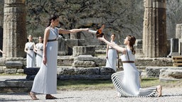 Am Tempel der Hera im antiken Olympia in Griechenland entzünden zwei Priester-Darstellerinnen das Olympische Feuer. © picture alliance/Kyodo 