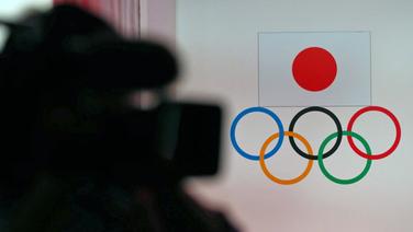 Ein Kameramann filmt die Olympischen Ringe und die japanische Flagge. © imago images / AFLOSPORT 