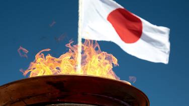 Die olympischen Feuer vor der Flagge Japans © imago images/ANE Edition 