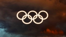 Die Olympischen Ringe vor dunklen Wolken © imago/Xinhua 